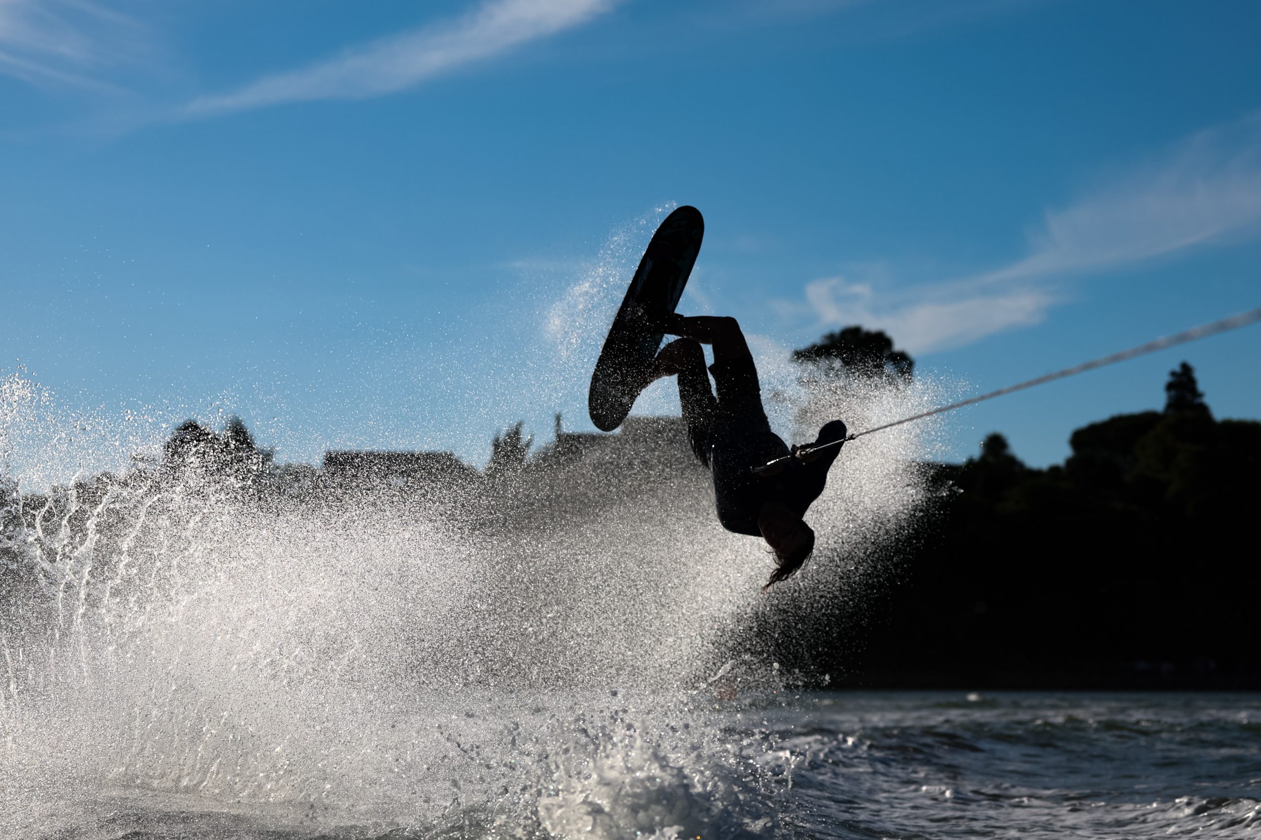 Trick skier backlit with spray